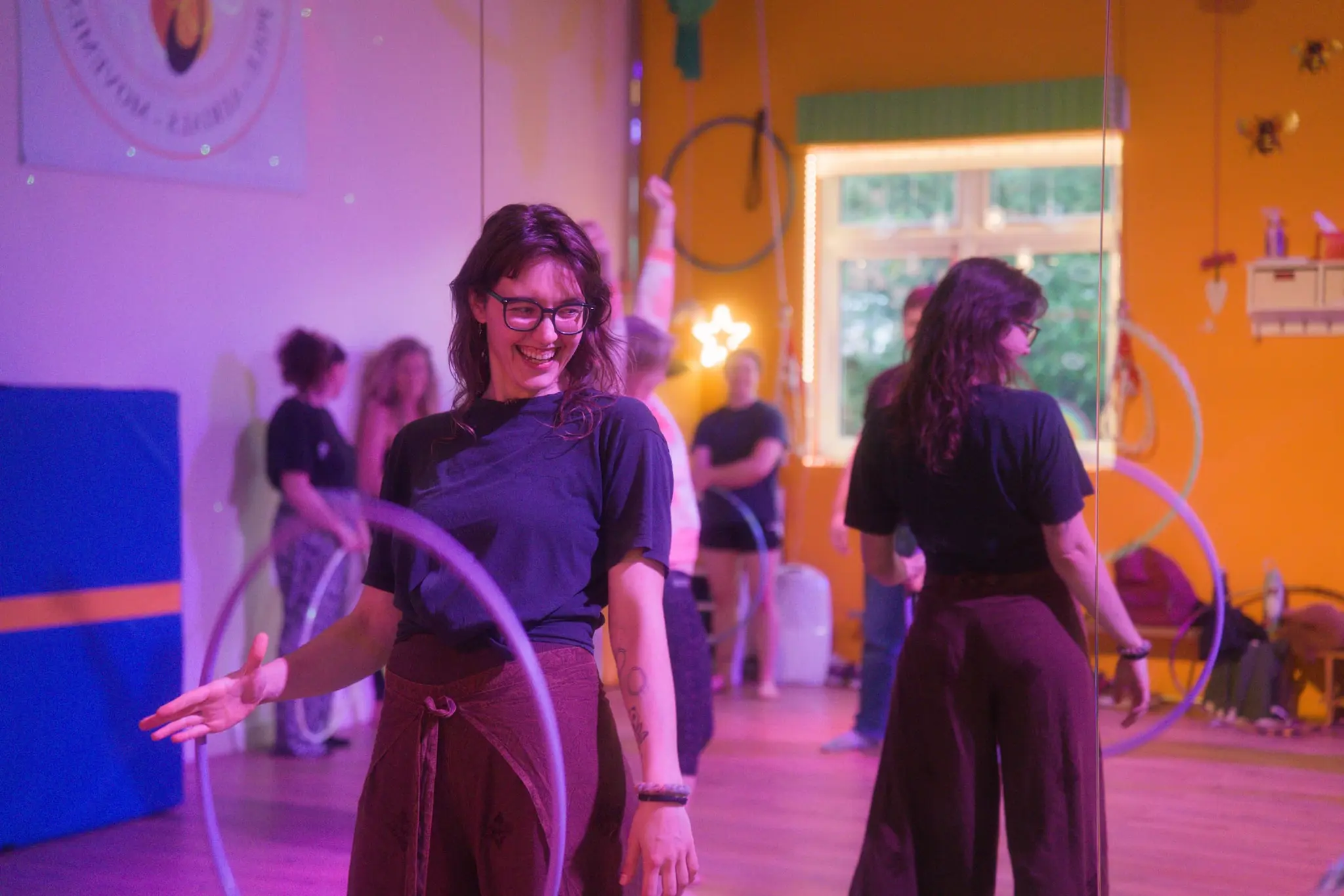 Osha, founder of Flowsha, laughing during a hula hoop workshop