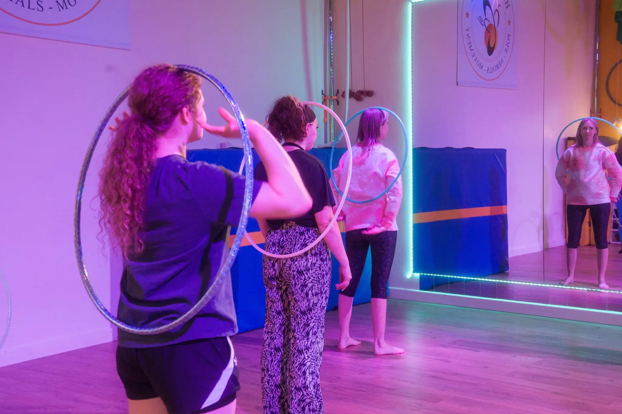 Hoopers reaching out with their hoops during a LED-lit group class