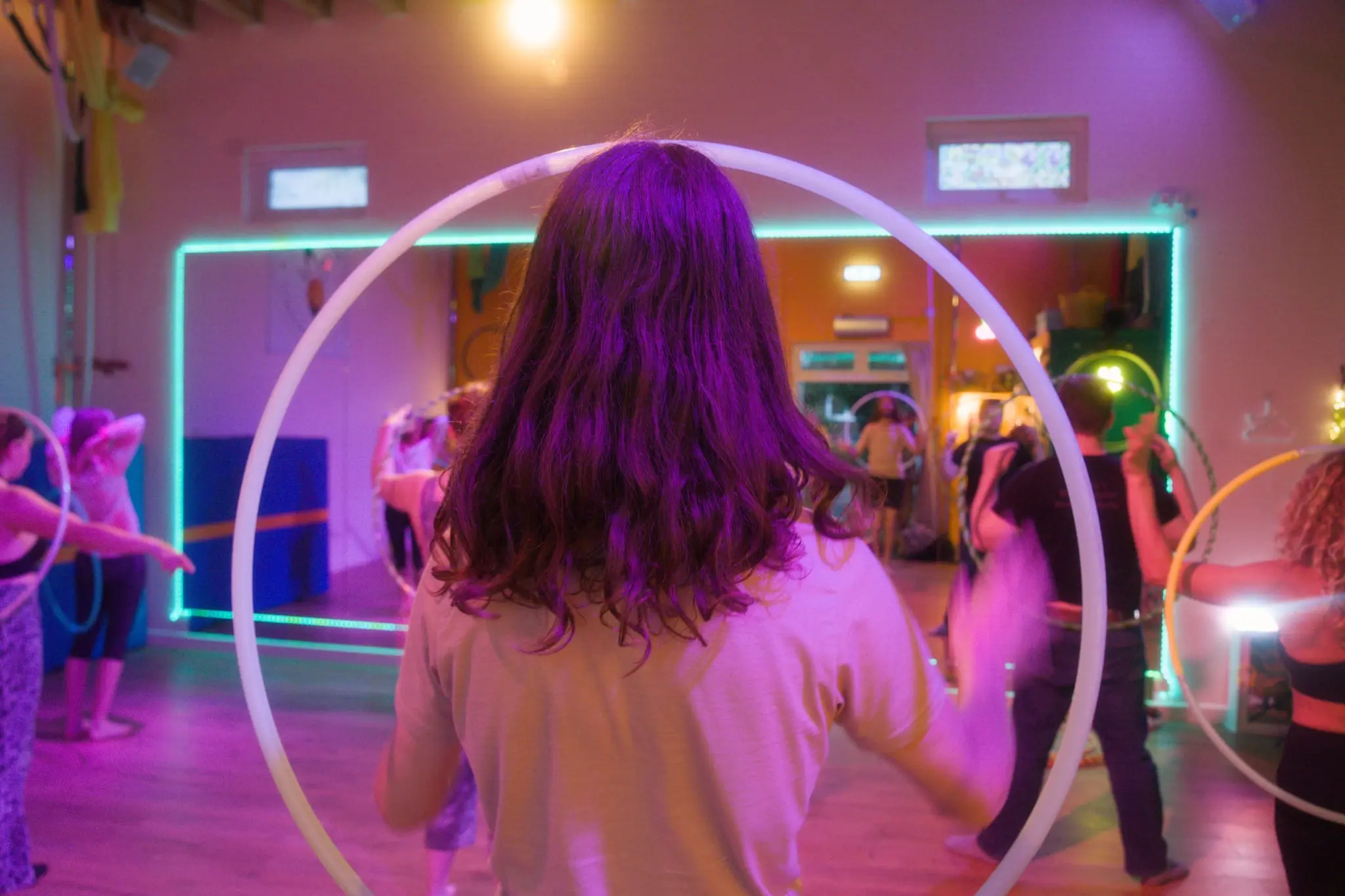 Hooper framed by a spinning hula hoop in soft purple light